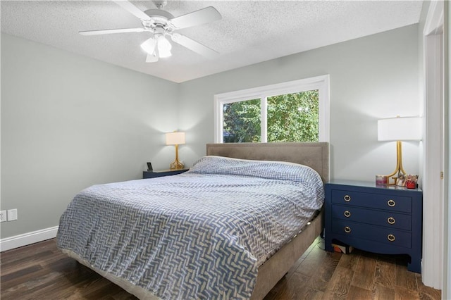 bedroom with ceiling fan, dark hardwood / wood-style flooring, and a textured ceiling