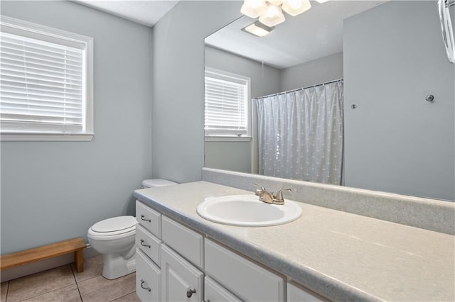 bathroom with toilet, vanity, and tile patterned floors