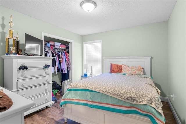 bedroom featuring hardwood / wood-style floors, a textured ceiling, and a closet