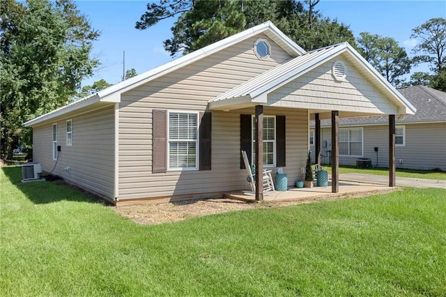 bungalow-style home featuring covered porch, a front lawn, and central air condition unit