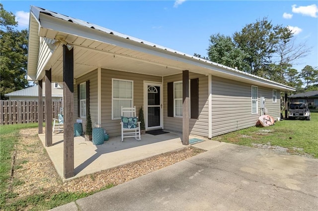 rear view of property with a porch and a yard