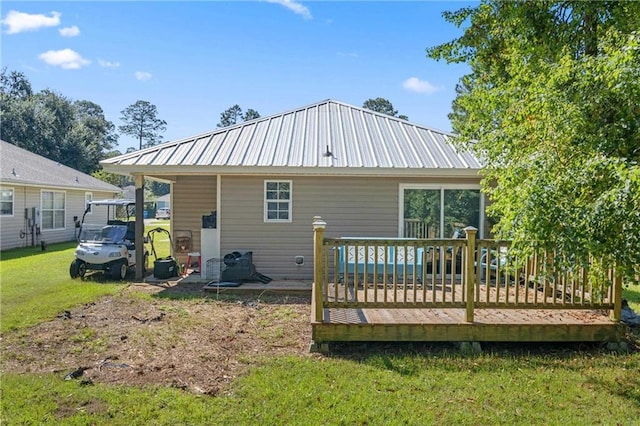 back of house featuring a lawn and a wooden deck