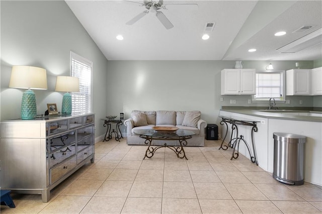 tiled living room featuring ceiling fan, sink, and vaulted ceiling