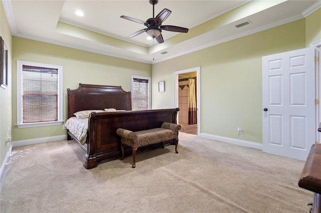 carpeted bedroom featuring baseboards, visible vents, ornamental molding, and a raised ceiling
