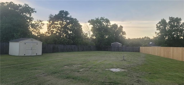 13556 James Copeland Dr, Mobile, AL 36695 - yard at dusk featuring a shed and a fenced backyard