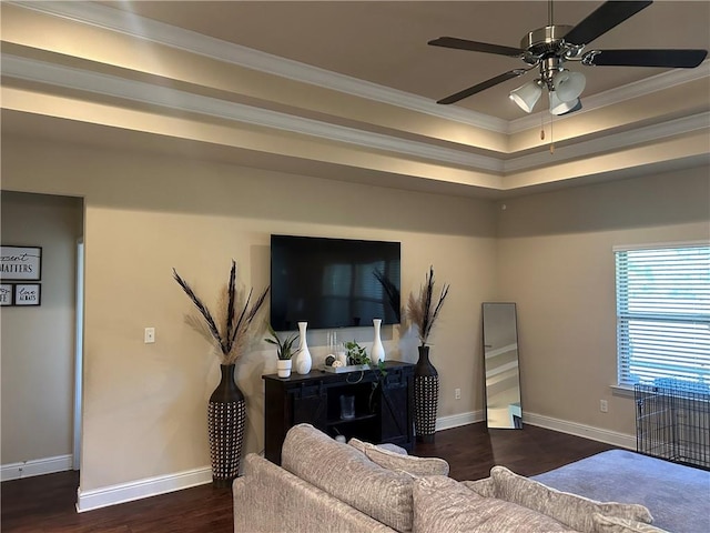 living area with dark wood-style floors, baseboards, ornamental molding, and a ceiling fan