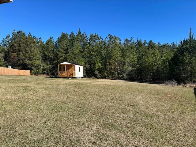 view of yard featuring fence and a forest view