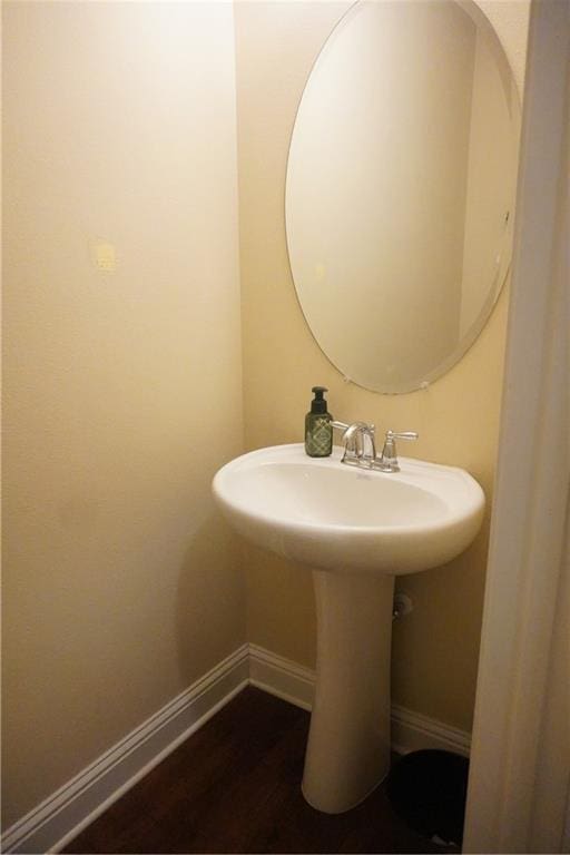 bathroom featuring a sink, baseboards, and wood finished floors