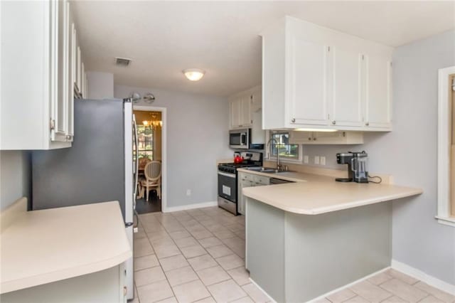 kitchen with visible vents, light countertops, a peninsula, and stainless steel appliances