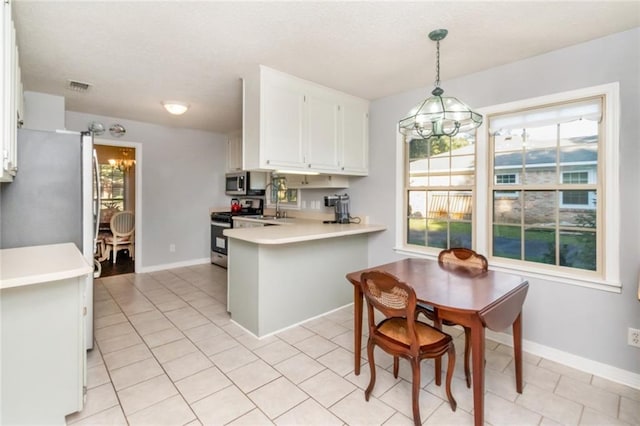 kitchen featuring visible vents, white cabinets, light countertops, a peninsula, and stainless steel appliances
