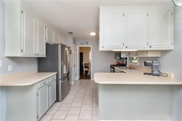 kitchen featuring stainless steel fridge with ice dispenser, a peninsula, visible vents, light tile patterned flooring, and light countertops