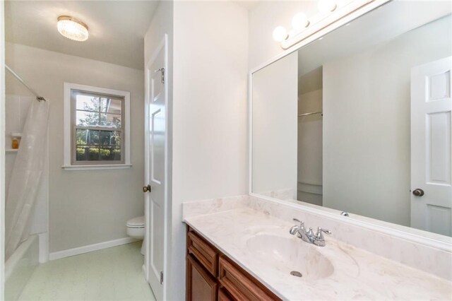 full bath featuring shower / tub combo, toilet, vanity, and baseboards