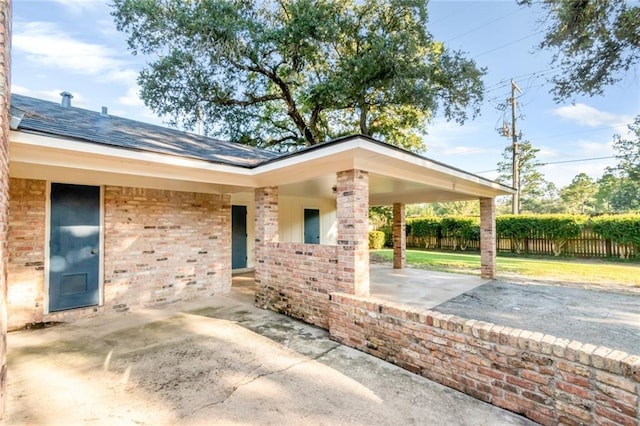 exterior space featuring a patio area, fence, and brick siding