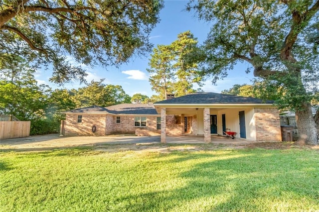 rear view of property with fence and a lawn