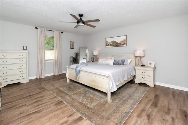 bedroom featuring ceiling fan, dark hardwood / wood-style flooring, and a textured ceiling