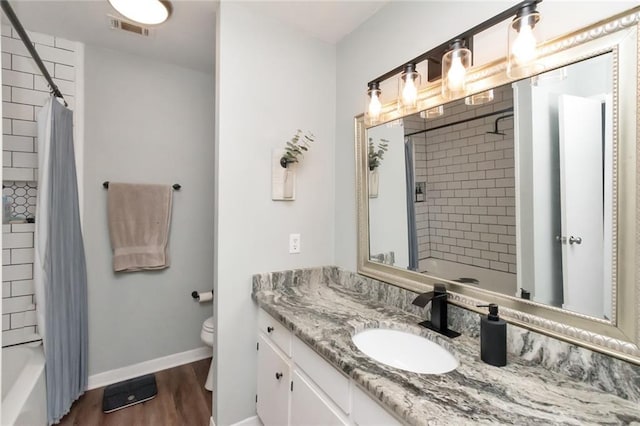 full bathroom with hardwood / wood-style flooring, vanity, toilet, and shower / tub combo