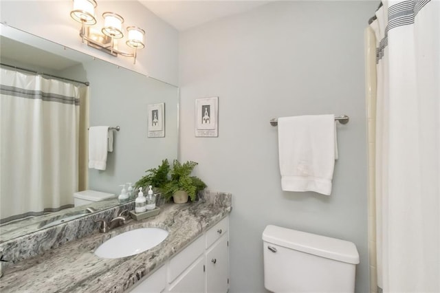 bathroom featuring vanity, curtained shower, and toilet