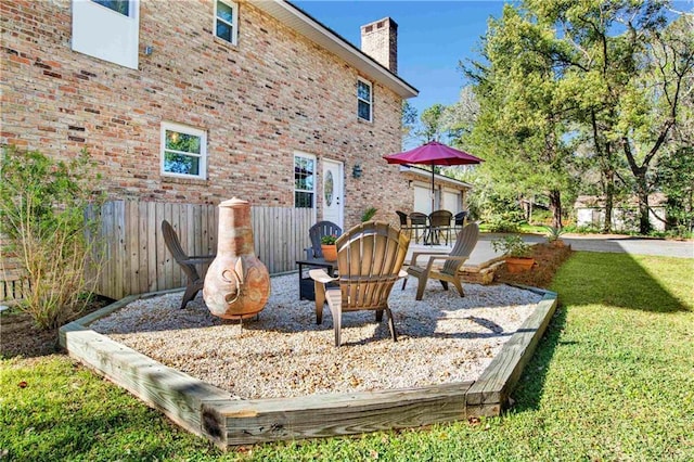 view of playground with a lawn, fence, and a patio