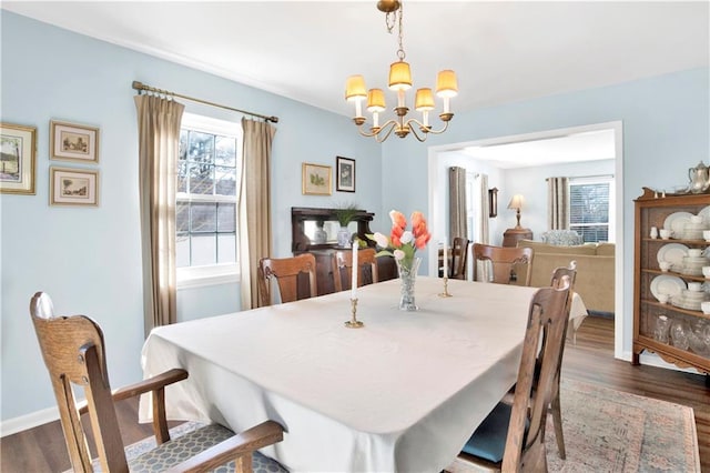 dining space with a wealth of natural light, a chandelier, dark wood-style floors, and baseboards