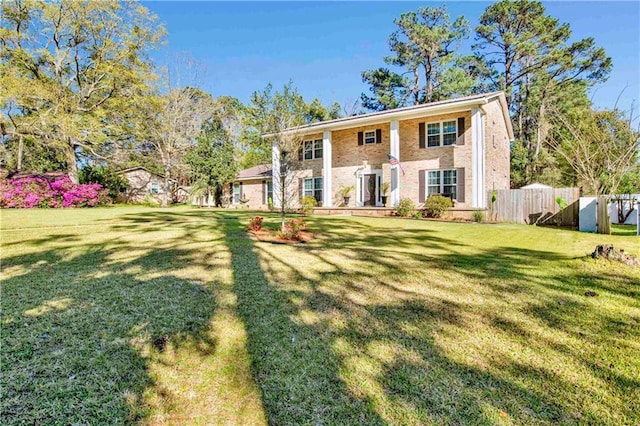 view of front of home with fence, a front yard, and brick siding