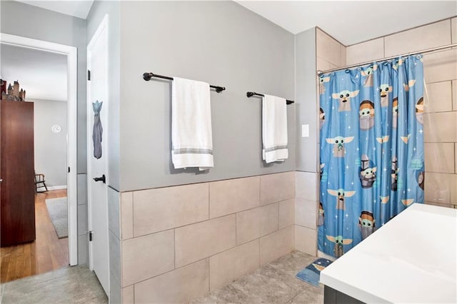 full bathroom featuring a shower with shower curtain and tile walls