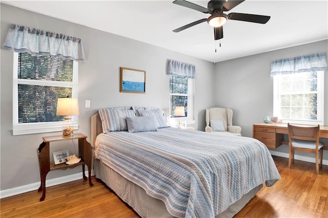 bedroom featuring baseboards, wood finished floors, and ceiling fan