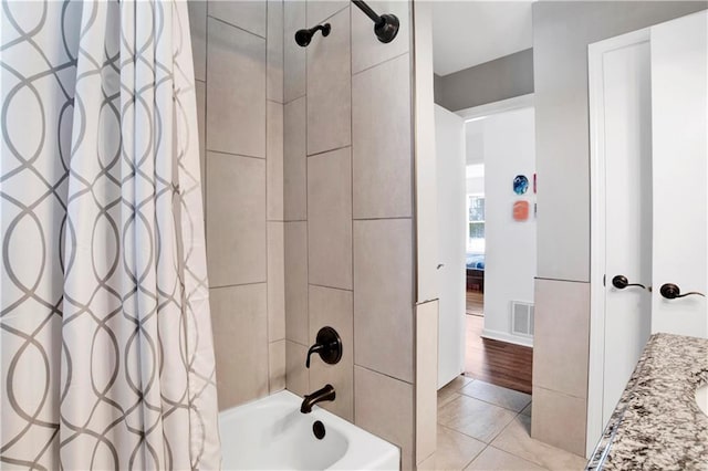 full bath with tile patterned floors, shower / bathtub combination with curtain, visible vents, and baseboards