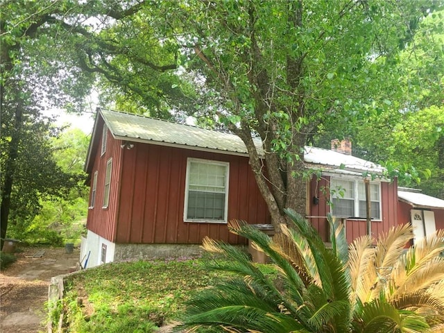 exterior space featuring board and batten siding and metal roof