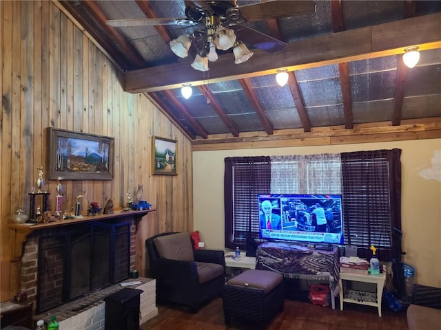 living area featuring ceiling fan, lofted ceiling with beams, a fireplace, wood finished floors, and wooden walls