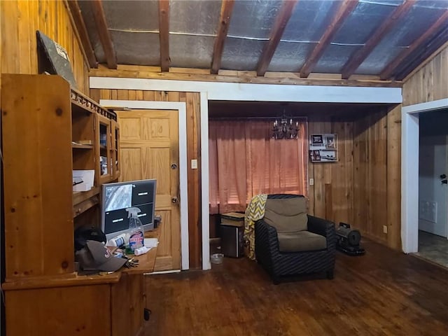 living area featuring wood finished floors, wood walls, and a notable chandelier
