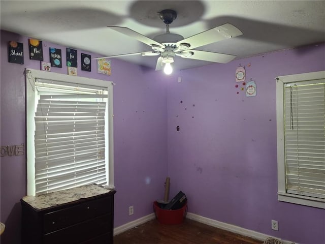 unfurnished bedroom with baseboards, a ceiling fan, and wood finished floors