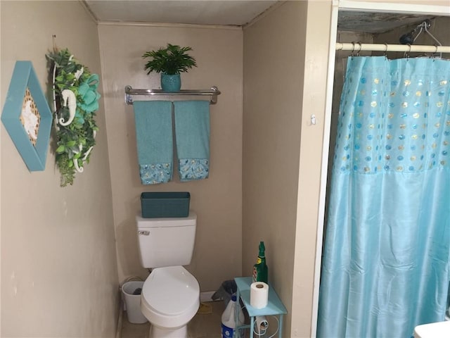 bathroom featuring toilet and curtained shower
