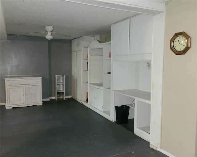 basement featuring a ceiling fan and a textured ceiling