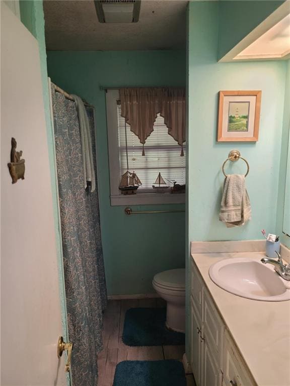 full bathroom with vanity, baseboards, toilet, visible vents, and wood finished floors