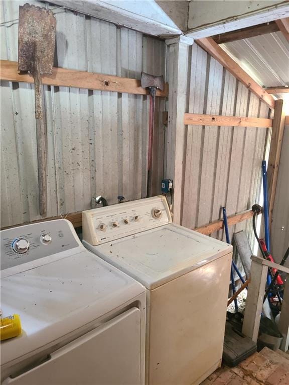 laundry area featuring laundry area, separate washer and dryer, and wooden walls