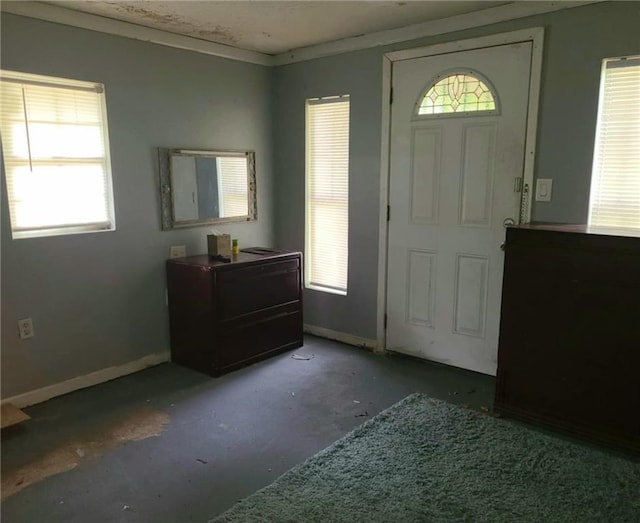 foyer entrance featuring baseboards and concrete flooring