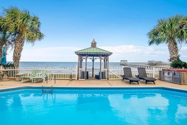 view of swimming pool with a gazebo, a fenced in pool, a water view, and fence