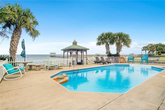 view of pool with a fenced in pool, a water view, a gazebo, fence, and a patio