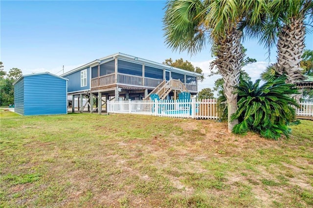 back of property with a fenced in pool, a sunroom, and a yard