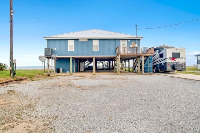 coastal home featuring a carport, driveway, central AC, and stairway