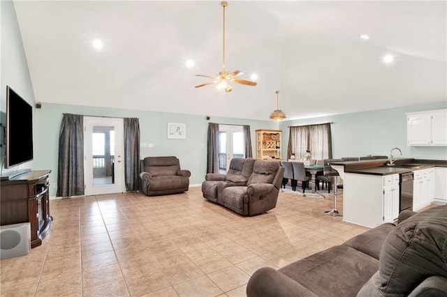 tiled living room featuring ceiling fan, a healthy amount of sunlight, sink, and vaulted ceiling