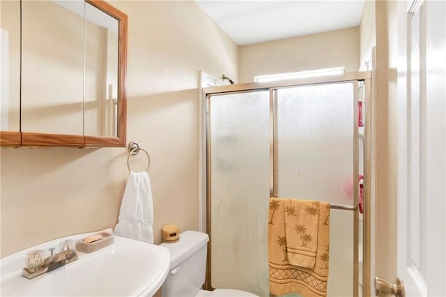 bathroom with toilet, an enclosed shower, and sink