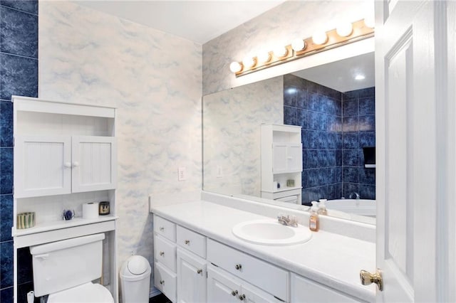 bathroom featuring vanity, toilet, and tile walls