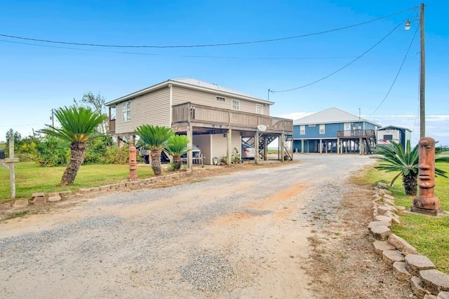 view of front facade with driveway, a carport, and stairway
