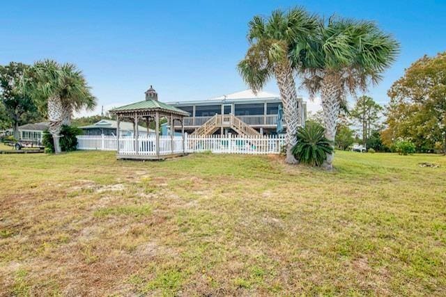 back of house featuring a gazebo, a yard, and a sunroom