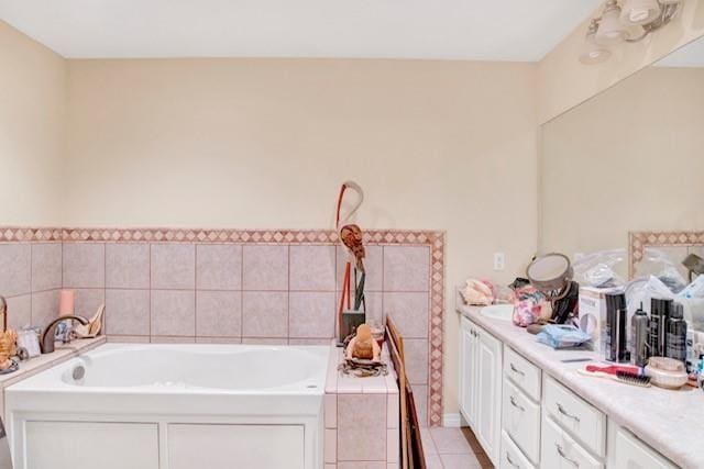 bathroom with tile patterned floors, vanity, and tiled tub