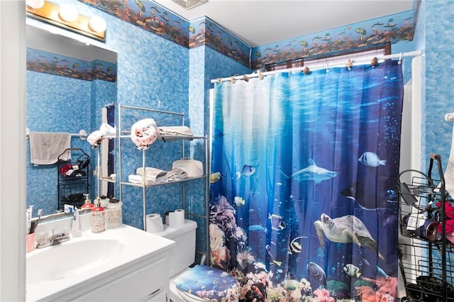 bathroom featuring wallpapered walls, a shower with curtain, vanity, and toilet