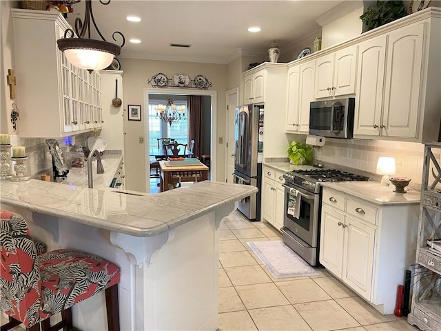 9849 Aspen Cir, Daphne, AL 36527 - kitchen featuring stainless steel appliances, backsplash, a breakfast bar, light tile patterned floors, and recessed lighting