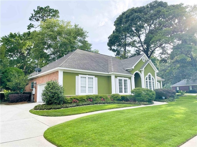 9849 Aspen Cir, Daphne, AL 36527 - view of front of home featuring a front lawn, a garage, a shingled roof, and stucco siding
