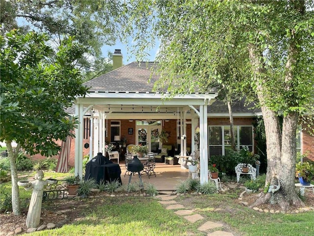 9849 Aspen Cir, Daphne, AL 36527 - back of house featuring roof with shingles, a chimney, brick siding, and a patio